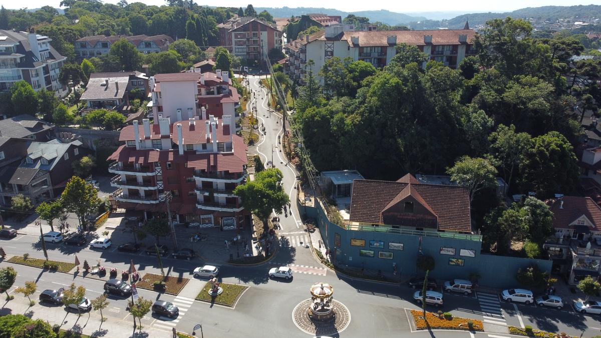 Imagem aérea de Gramado mostrando luxuosos condomínios e arborização, destacando a valorização imobiliária em comparação com grandes capitais.